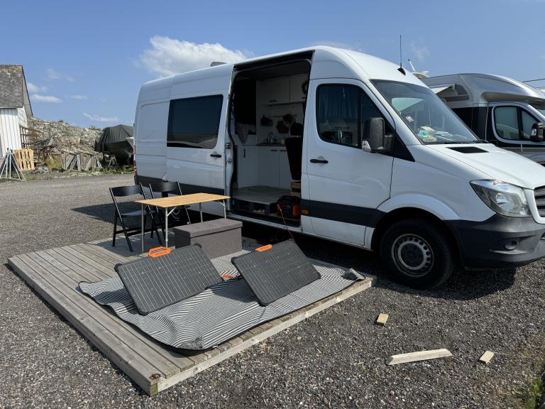 Zwei Solarpanele auf einem Podest neben einem Sprinter auf der Insel Hälsö in Schweden